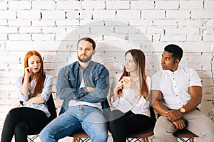 Portrait of stressed bored young diverse multicultural vacancy applicant waiting job interview with hr, sitting in queue