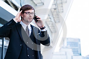 Businessman speaks by phone with his head in hands in frustration.