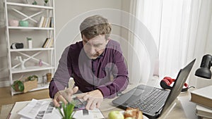 Portrait of stressed businessman typing on laptop keyboard and checking smartphone. Worried Caucasian middle aged man