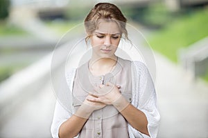 Portrait of stressed or lonely woman with heart ache outdoors