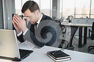 Portrait of stressed out and worried troublesome overworked businessman entrepreneur looking documents report in modern