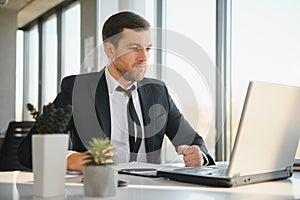 Portrait of stressed out and worried troublesome overworked businessman entrepreneur looking documents report in modern