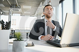 Portrait of stressed out and worried troublesome overworked businessman entrepreneur looking documents report in modern