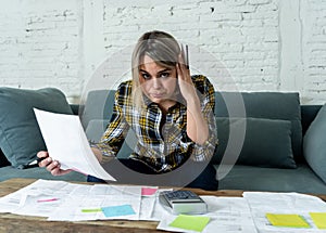 Portrait of stressed and overwhelmed young woman accounting home and business finances paying bills