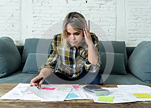 Portrait of stressed and overwhelmed young woman accounting home and business finances paying bills