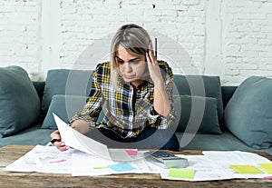 Portrait of stressed and overwhelmed young woman accounting home and business finances paying bills