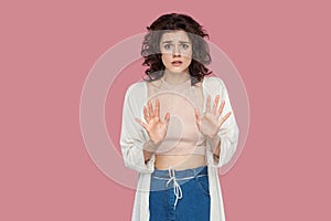 Portrait of stressed scared beautiful brunette young woman with curly hairstyle in casual style standing and looking at camera