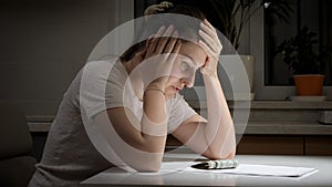 Portrait of stressed woman having few money sitting alone at night