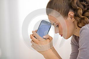 Portrait of stressed young woman with cell phone