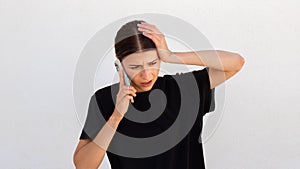 Portrait of stressed young woman talking on smartphone