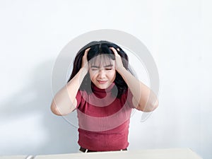 Portrait of a stressed young women holding head in hands with the background. Unhappy Asian girl with worried stressed face