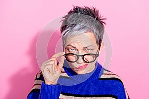 Portrait of strict funny woman wear striped pullover fingers touch glasses suspiciously look at you isolated on pink