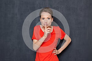 Portrait of strict indignant girl showing silence sign