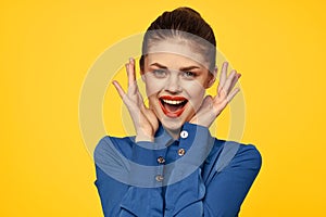 Portrait of a strict woman in a blue shirt with red lips on a yellow background emotions fun