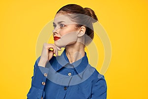 portrait of a strict woman in a blue shirt with red lips on a yellow background emotions fun