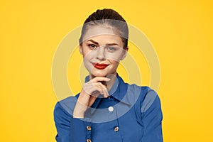 portrait of a strict woman in a blue shirt with red lips on a yellow background emotions fun