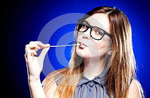 Portrait of strict young woman with nerd glasses and chewing gum