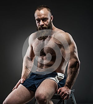 Portrait of strong bearded man with perfect abs, pecs shoulders,biceps, triceps and chest