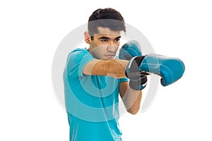 Portrait of strong brunette sports man practicing box in blue gloves isolated on white background