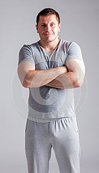 Portrait of strong healthy handsome Athletic Man Fitness Model posing near dark gray wall