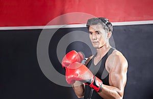 Portrait of Strong young athlete sportsman muay thai boxer fighting in gym, muscular handsome boxing man fighter with copy space