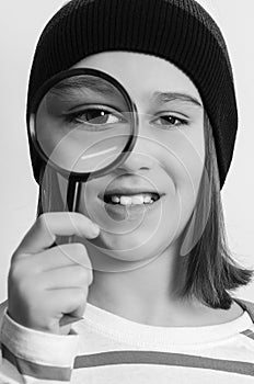 Portrait of student boy with magnifier. School, learning and development concept. Boy looking through magnifying glass