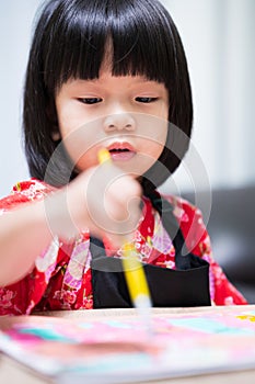 Portrait of student child painting on paper art. Little artist girl learning art lesson in class. Kid wearing black apron uniform