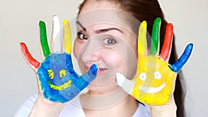 Portrait student girl smiling girl showing painted colorful hands with smiles. Concept education, creativity, art and