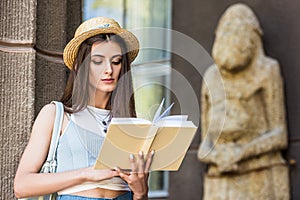 portrait of student in straw hat reading book