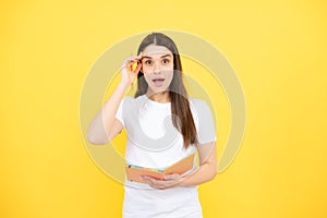 Portrait of student woman. College or high school ducation. Serious young woman with notebooks at camera on yellow