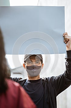 Portrait students holding blank paper conducting demonstrations