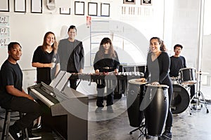 Portrait Of Students At Performing Arts School Playing In Band At Rehearsal With Teacher