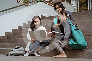 Portrait students sit down working in groups