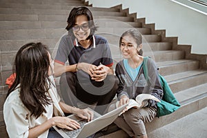 Portrait students sit down working in groups