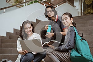 Portrait students sit down working in groups