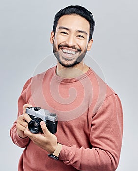 Portrait, studio and man with camera, tourist and photographer against a grey background. Face, male creative and guy