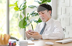 Portrait studio shot of Asian professional successful male businessman employee in formal shirt with necktie sitting look at