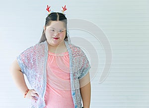 Portrait studio shot of Asian young cute chubby female down syndrome autistic model wear red dear antlers headband and casual