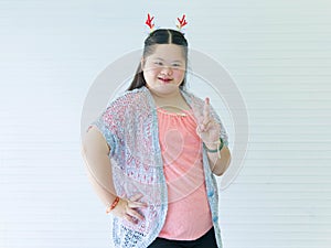 Portrait studio shot of Asian young cute chubby female down syndrome autistic model wear red dear antlers headband and casual