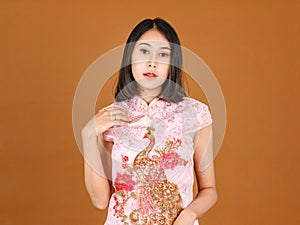 Portrait closeup studio shot millennial Asian female model in pink Chinese cheongsam qipao traditional peacock & flowers pattern