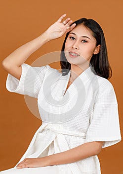 Portrait studio shot of millennial young Asian short black hair female model in white shower rope standing smiling look at camera