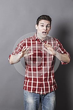 Portrait of stunned sportsman using hands to watch out