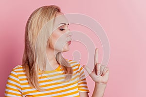 Portrait of stunning blonde girl hands make pistol gesture blow kiss on pink background