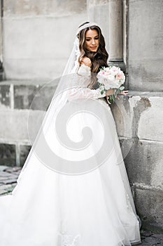 Portrait of stunning bride with long hair posing with great bouquet