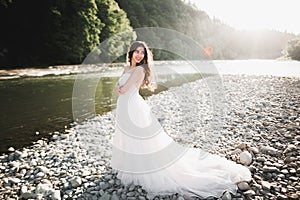 Portrait of stunning bride with long hair standing by the river