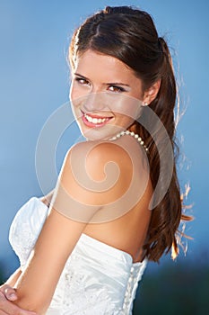 Portrait of a stunning bride. Portrait of a beautiful young bride looking over her shoulder and smiling at the camera.