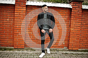 Portrait of stylish arab beard man wear grey turtleneck and black jaket. Arabian model guy against brick wall