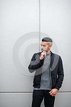 Portrait of stylish arab beard man wear grey turtleneck and black jaket. Arabian model guy against steel wall