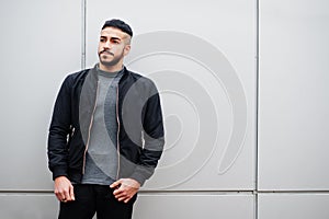 Portrait of stylish arab beard man wear grey turtleneck and black jaket. Arabian model guy against steel wall