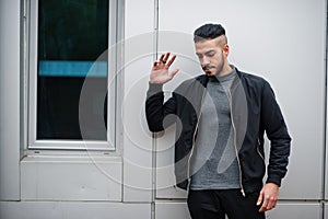 Portrait of stylish arab beard man wear grey turtleneck and black jaket. Arabian model guy against steel wall